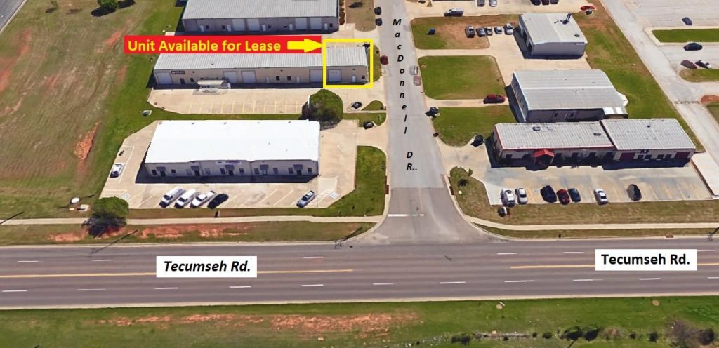 Aerial view of a commercial area with a 'For Lease' sign and surrounding roads.