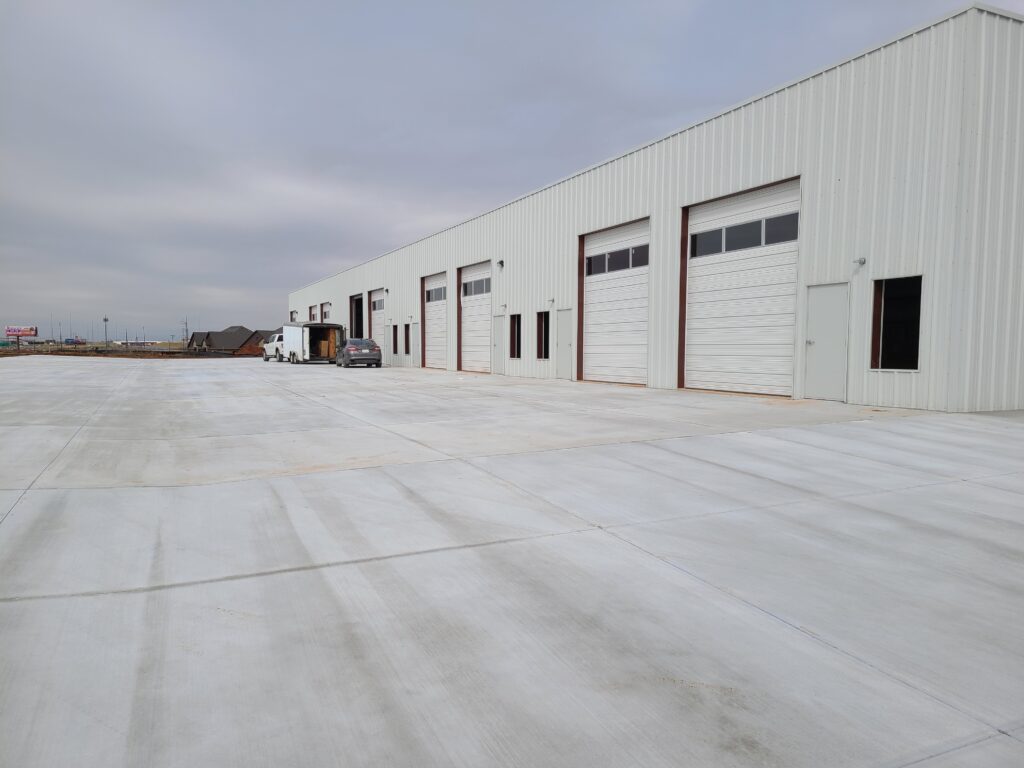Large industrial warehouse with multiple loading docks and a wide concrete area.