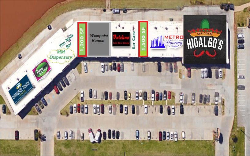 Aerial view of a parking lot and surrounding buildings with visible signs.