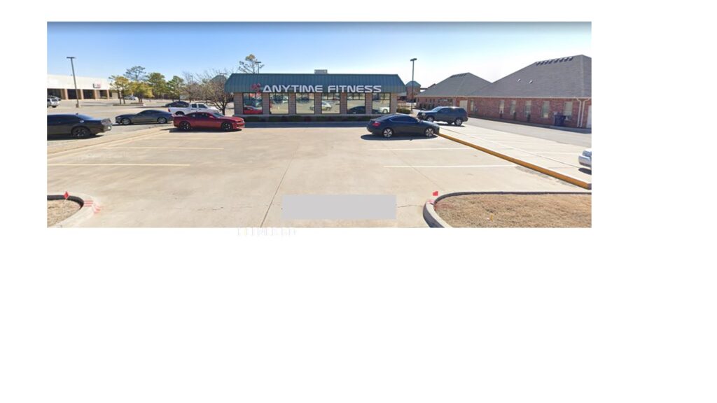 Exterior of a single-story convenience store with parked cars.